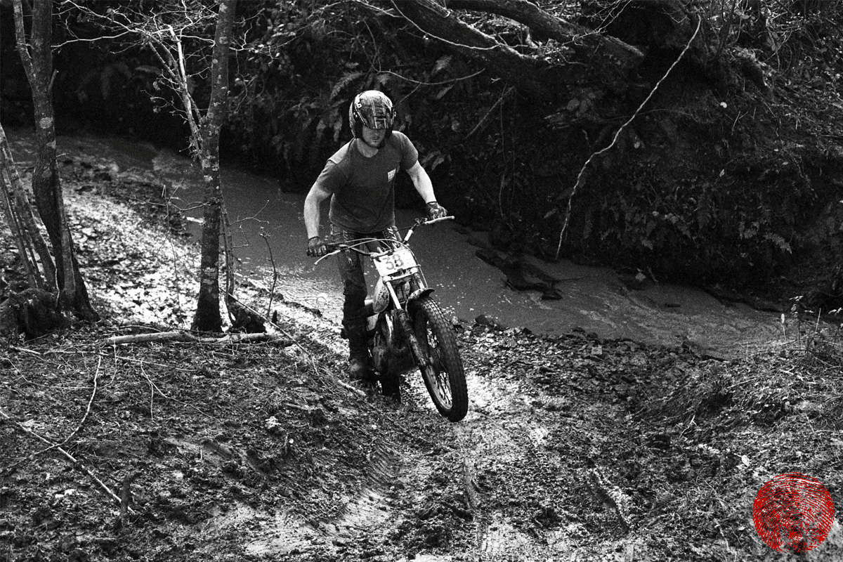 trials rider riding up out of stream on yamaha ty175