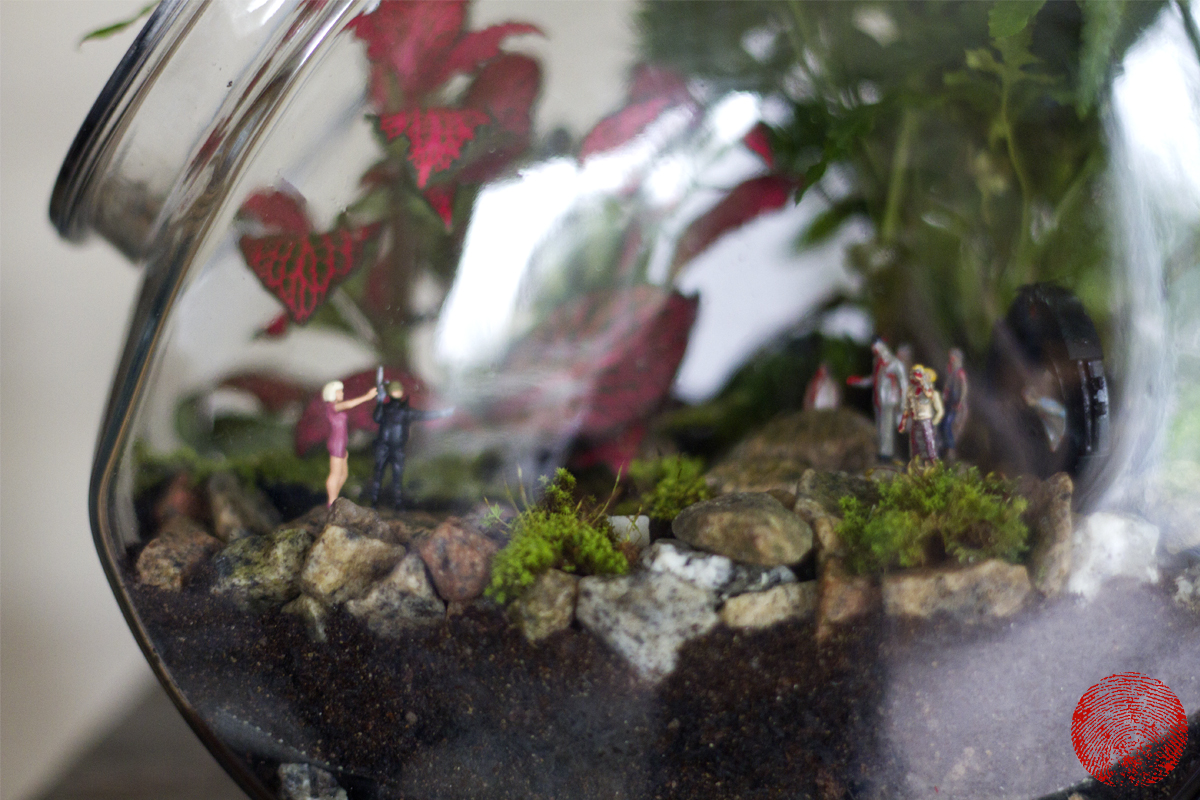 terrarium with zombie figurines scene