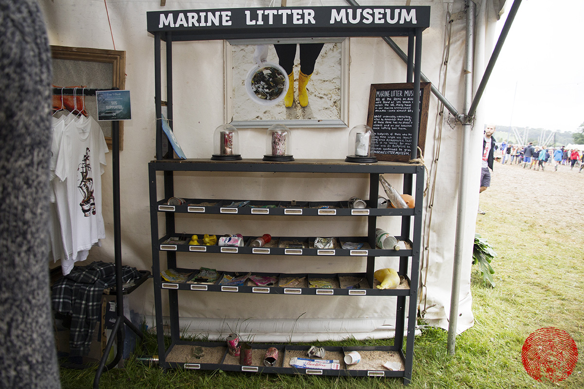 surfers against sewage's marine litter museum on display at somersault festival 2015 with a photograph by mat arney displayed behind it